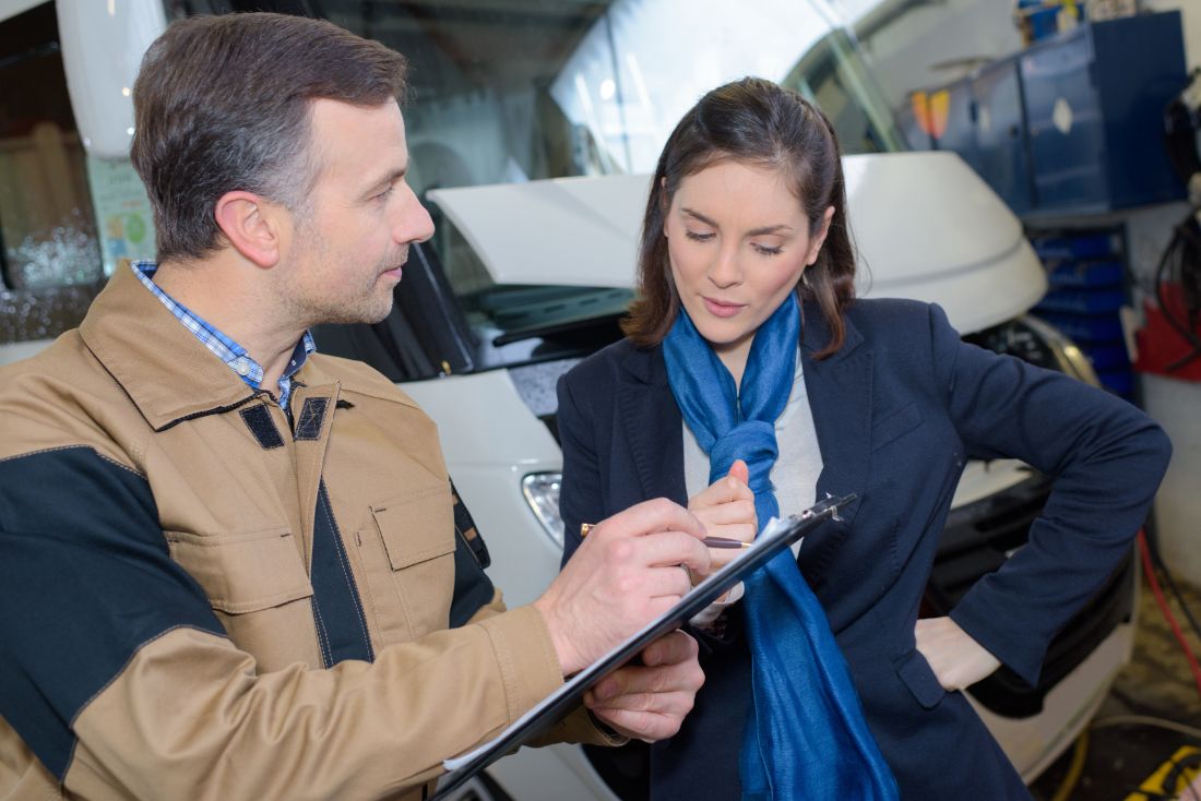 RV mechanic showing woman the warranty coverage